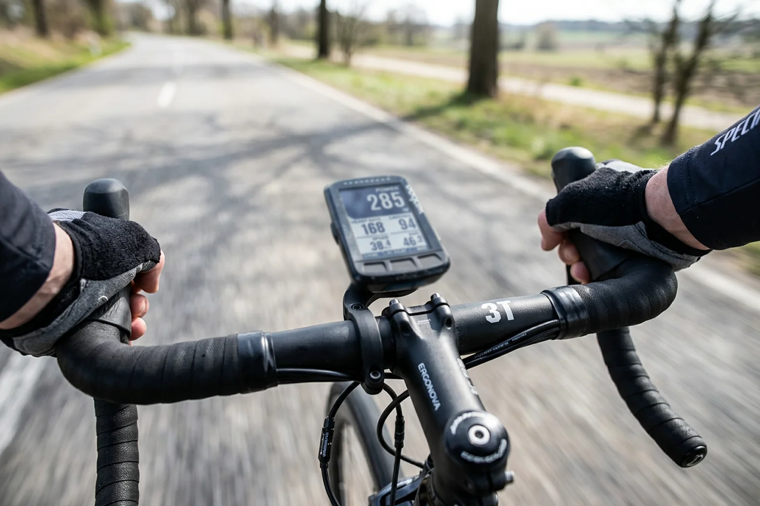 Ciclocomputador montado en el manillar de una bicicleta de carretera mostrando datos de vatios y frecuencia cardiaca